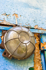 Image showing Old and dirty lamp on blue abandoned wall