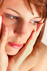 Image showing Closeup of a young woman holding her face with hands