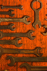 Image showing Many rusty spanners on wooden board