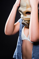 Image showing Girl wearing gasmask and white lingerie holding her head