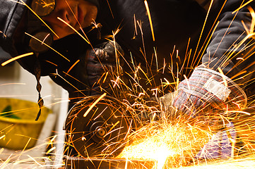 Image showing Welder cutting iron with sparks