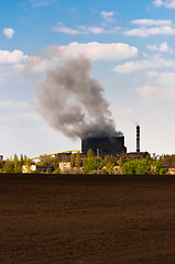 Image showing Dark smoke rising from the power plant against blue background