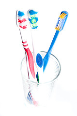 Image showing colorful toothbrushes in a glass over white