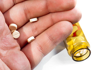 Image showing Hand of a man holding pills with medicine on background