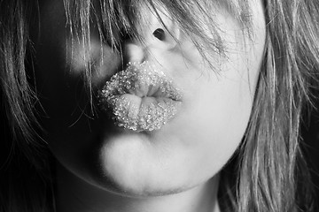 Image showing Beautiful young girl kissing with sugar on her mouth in black an