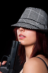 Image showing Beautiful young girl in hat holding pistol