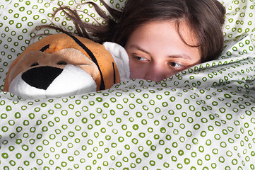 Image showing young girl in bed holding teddy bear