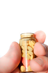 Image showing Hand holding medicine bottle full of pills