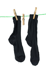 Image showing Two black socks hanging on rope