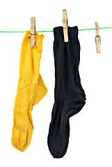 Image showing Yellow and black socks hanging on rope