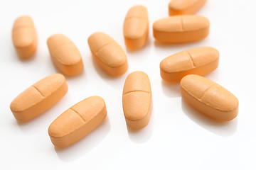 Image showing orange pills over white