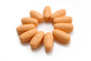 Image showing orange pills over white