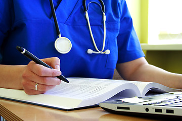 Image showing medical doctor with stethoscope is writing