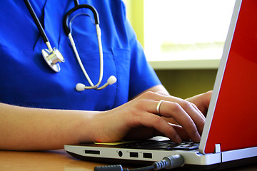 Image showing Doctor sitting at  desk with laptop computer