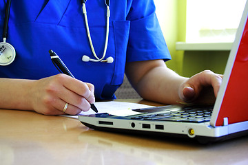 Image showing Doctor sitting at desk with laptop computer