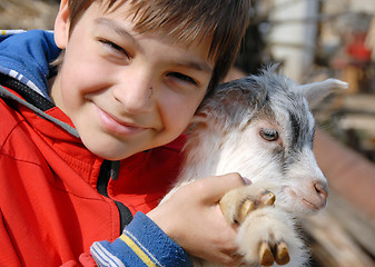 Image showing Teenage boy with goatling