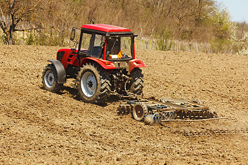 Image showing Tractor with disk harrow and rake