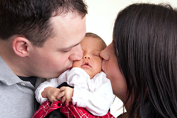 Image showing Happy Parents Kiss Their Newborn Baby