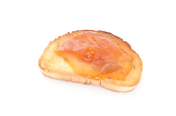 Image showing apricot jam over toast isolated