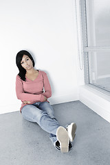 Image showing Depressed woman sitting on floor