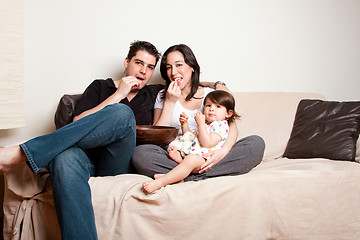 Image showing Happy family snacking on sofa couch