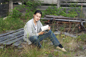 Image showing Girl reading a book at the cottage