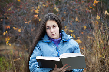 Image showing A girl with her hair reading a book