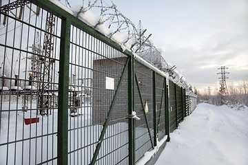 Image showing electrical substation behind a fence topped with barbed wire