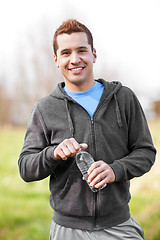 Image showing Mixed race man holding water bottle