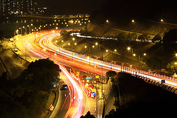 Image showing road with car traffic at night and blurry lights showing speed a