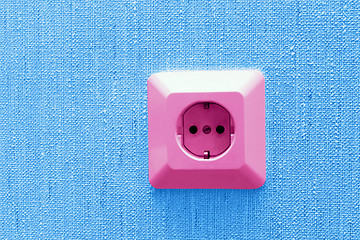 Image showing pink electric socket on blue wall