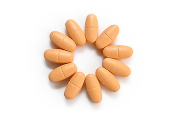 Image showing orange pills over white