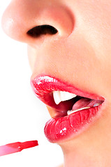 Image showing Close up of a girl with opened mouth, putting makeup on