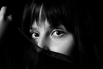 Image showing Young arabic girl hiding her face with a scarf in black and whit