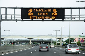 Image showing Warning sign on highway with some cars on the road