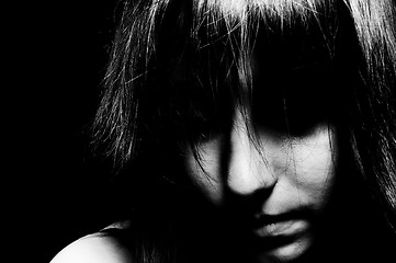 Image showing A sad girl looking down with her eyes unseen in black and white