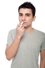 Image showing Young man applying lip balm