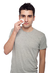 Image showing Young man cleaning face