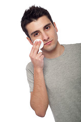 Image showing Young man cleaning face