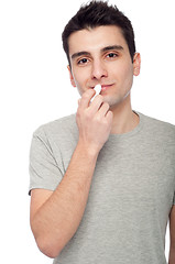 Image showing Young man applying lip balm