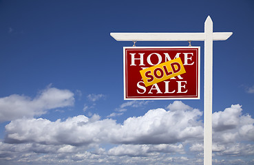 Image showing Red Sold Home For Sale Real Estate Sign Over Clouds and Sky