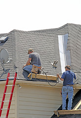 Image showing Roofers - Two men lay a new roof down. Teamwork (12MP camera)