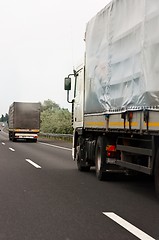Image showing Trucks traveling on highway delivering goods