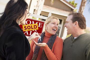 Image showing Hispanic Female Real Estate Agent Handing Keys to Excited Couple