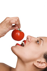 Image showing Young Woman Eating Tomatoes