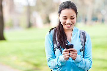 Image showing Asian student texting on the phone