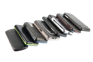 Image showing Row of modern mobile phones on white