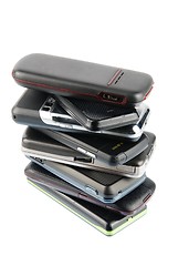 Image showing Heap of modern mobile phones on white