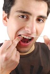 Image showing Man flossing his teeth