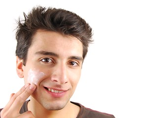 Image showing Smiling man applying face cream